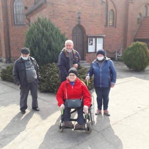 Na zdjęciu widać 4 osoby stojące przy Kościele św. Michała Archanioła w Broniszewicach